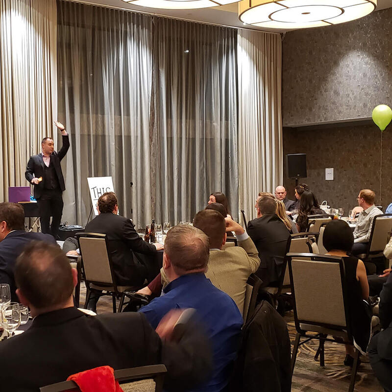 Jeff Newman performs his magic and mentalism show for a corporate audience at a holiday event.